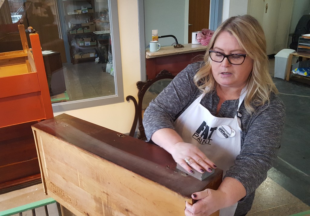 FAT Paint project: Victoria preps the wood surface, giving it a "once-over" with a medium-fine sanding block. 